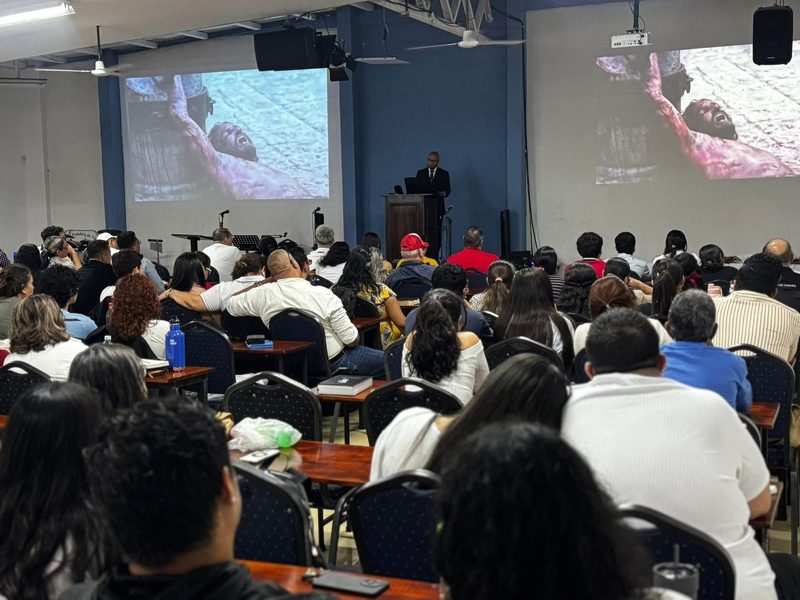 Congregación de Tibás siguiendo la predicación proyectada en pantalla